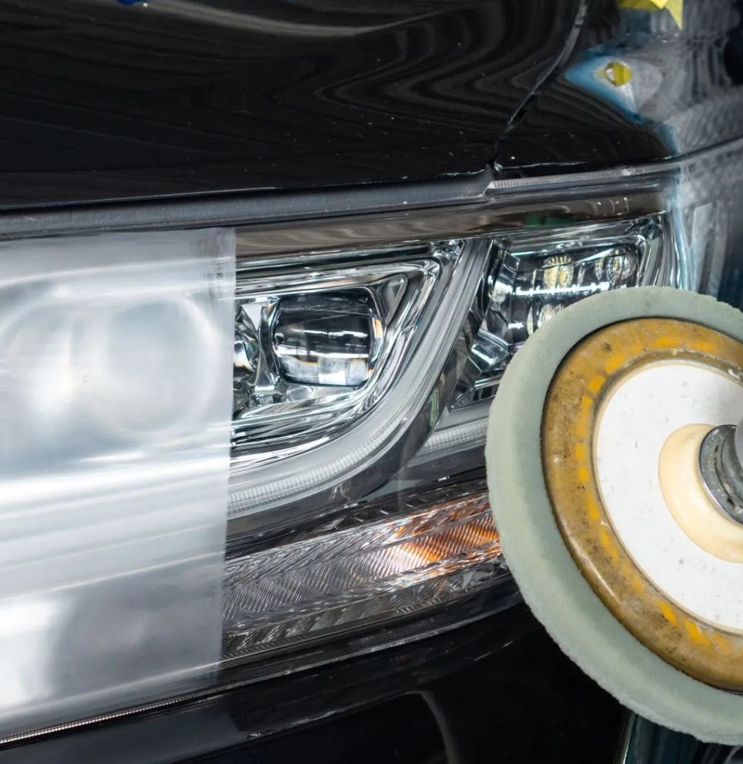 Faro di un'auto lucidato con un tampone abrasivo, che mostra una sezione opaca sul lato sinistro.