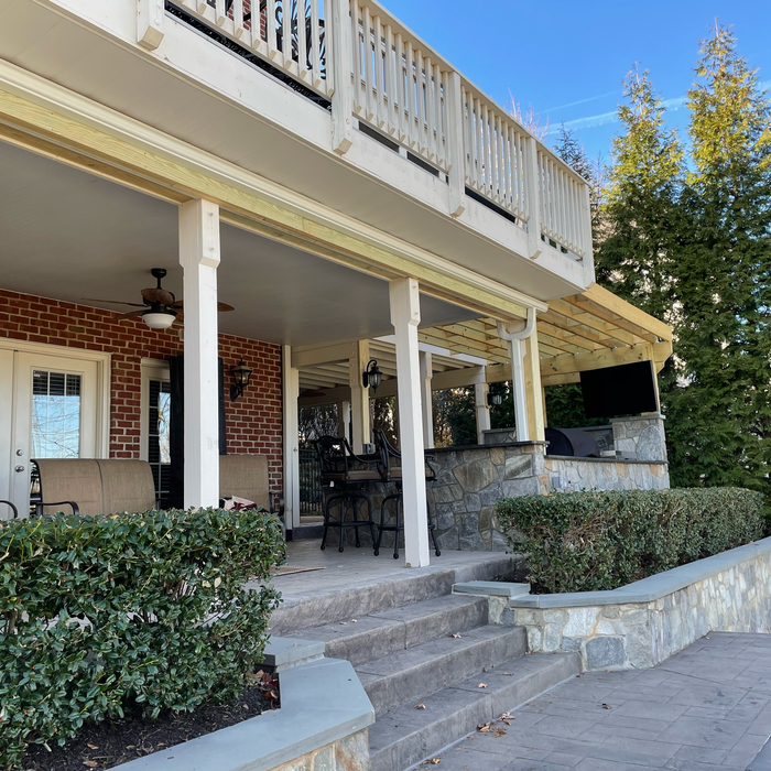 Outdoor patio with stone steps, a bar, and a second-story deck.