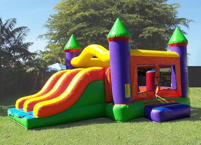 Colorful inflatable bounce house with slide in a sunny grassy yard