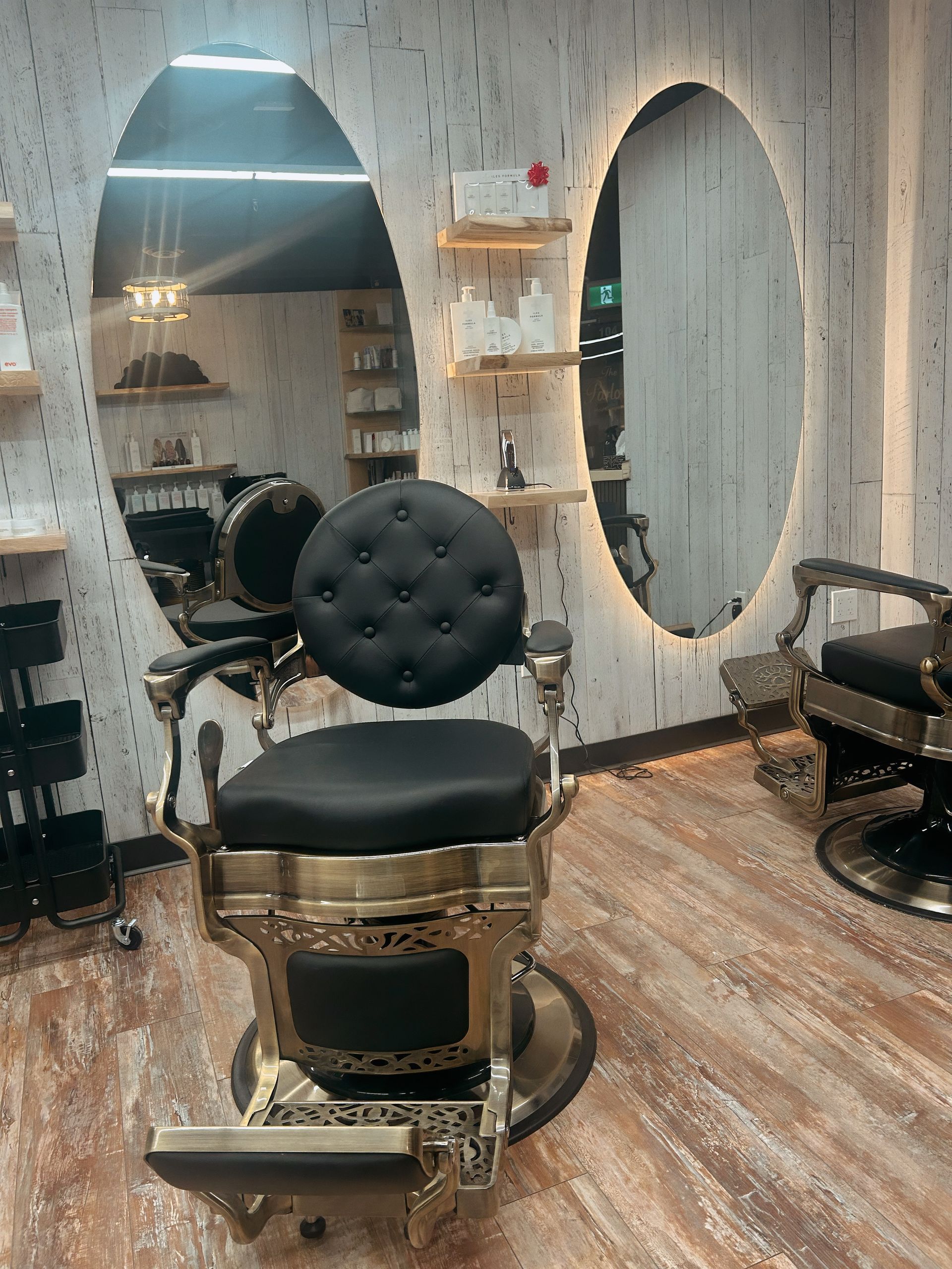 Barbershop chair in a modern salon with round mirrors and wood-patterned flooring