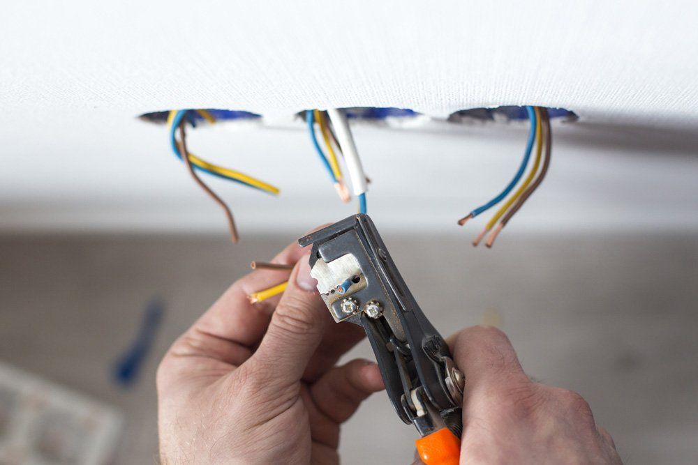 A person is cutting a wire with a pair of pliers.