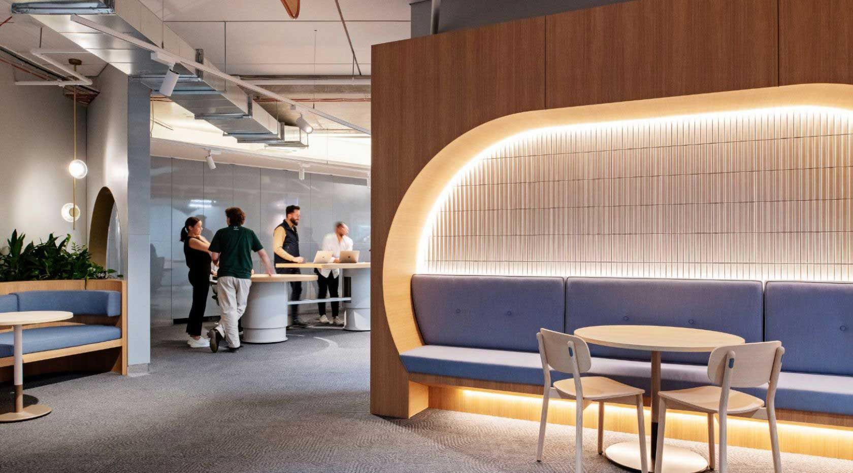 A Group Of People Are Standing Around Tables In A Room