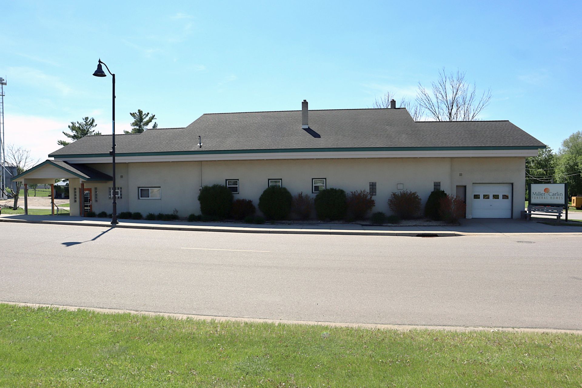 A small white building with a brown roof and a flag on top of it.
