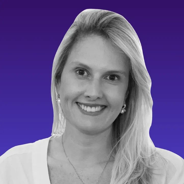 Uma mulher com longos cabelos loiros está sorrindo em uma foto em preto e branco.