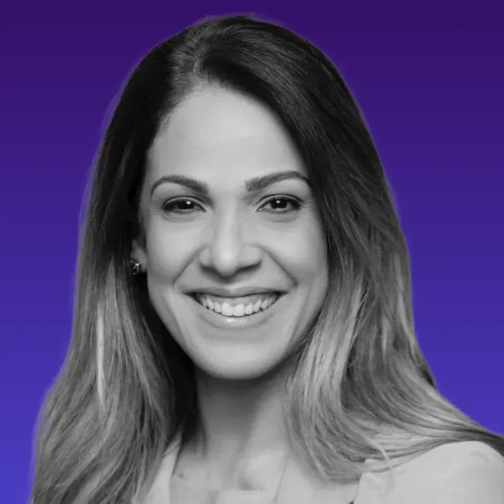 Uma mulher com cabelos longos está sorrindo em uma foto em preto e branco.