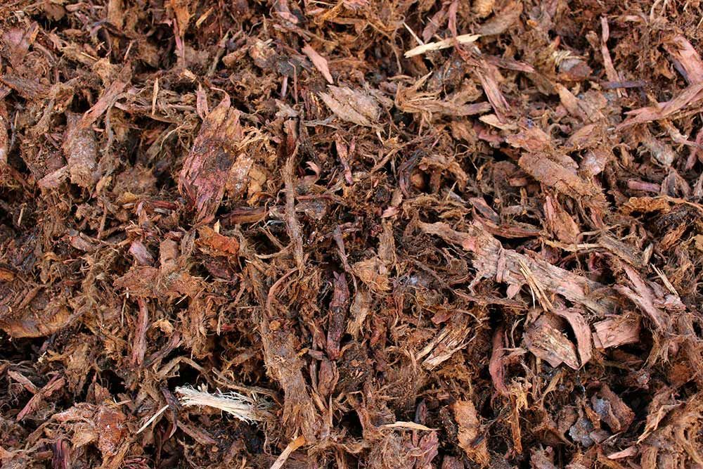 A Pile Of Brown Mulch With A Lot Of Leaves On It — Caloundra Landscape Supplies in Caloundra, QLD