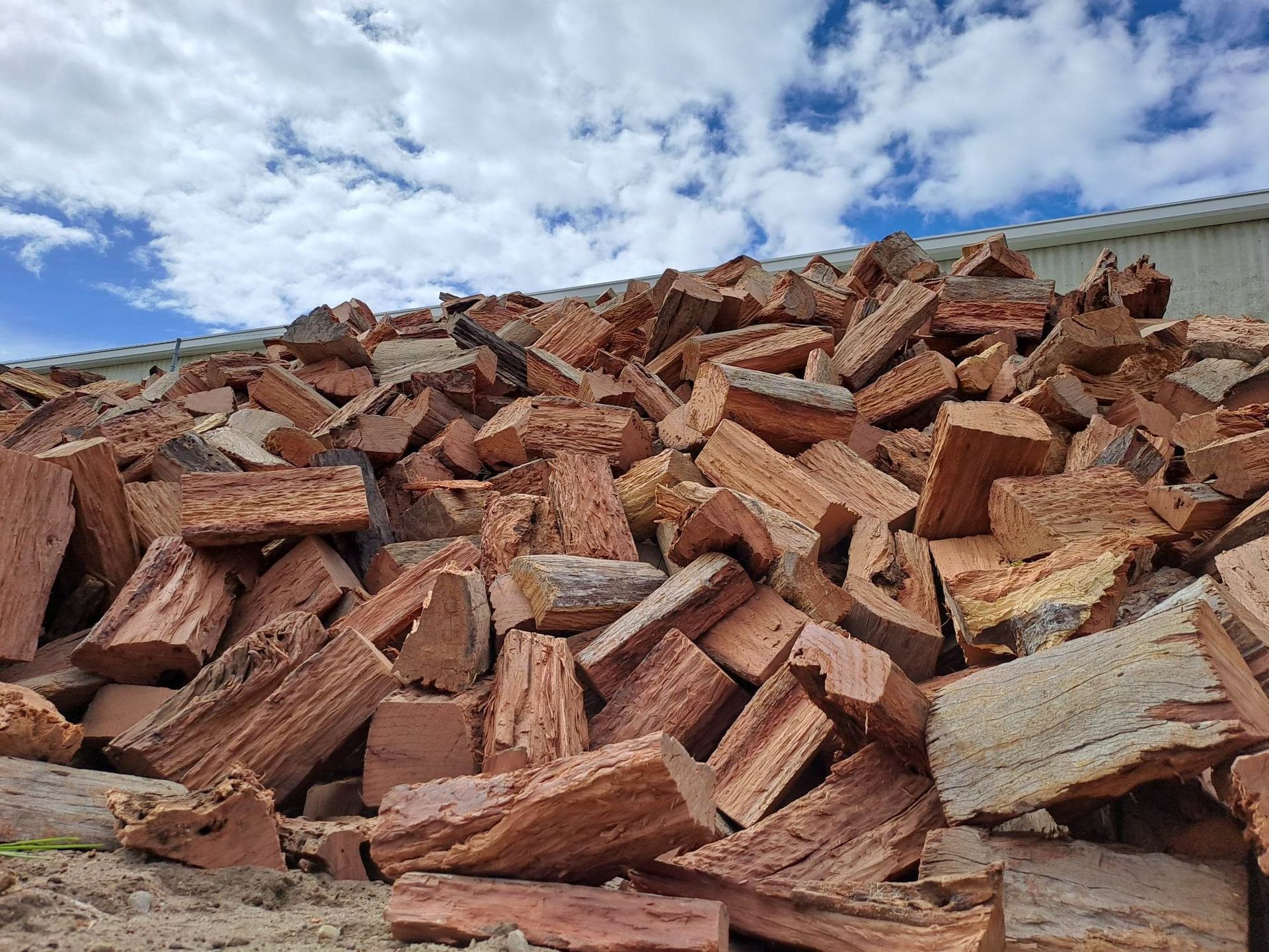 A White Bag Filled With Wood is Sitting on the Ground — Caloundra Landscape Supplies in Caloundra, QLD