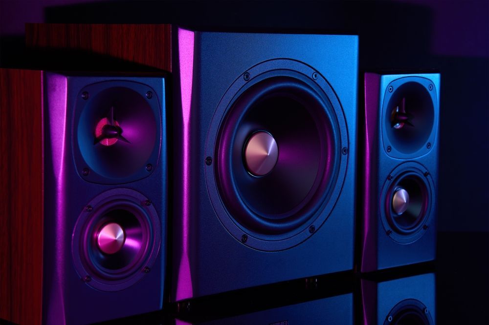 Three speakers are sitting next to each other on a table.