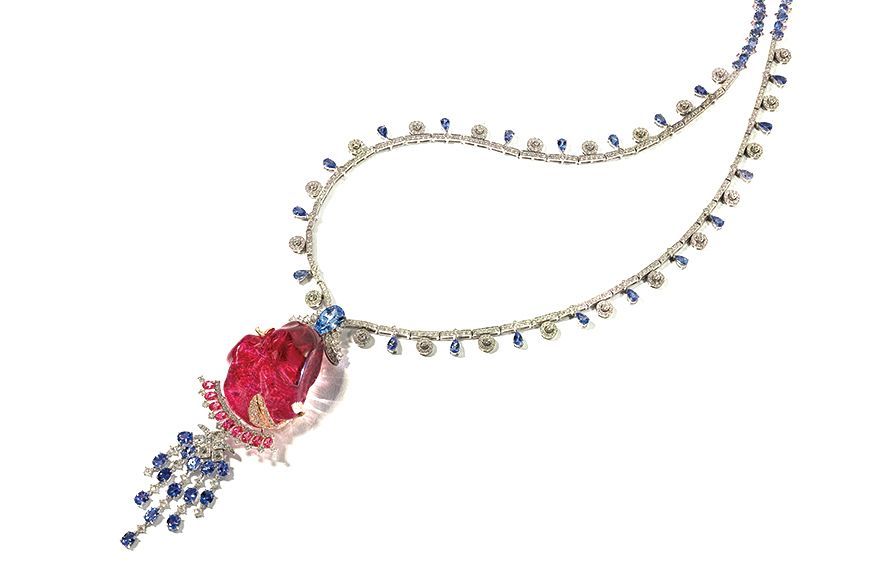 Elegant silver necklace with blue and red gemstone pendant on a white background