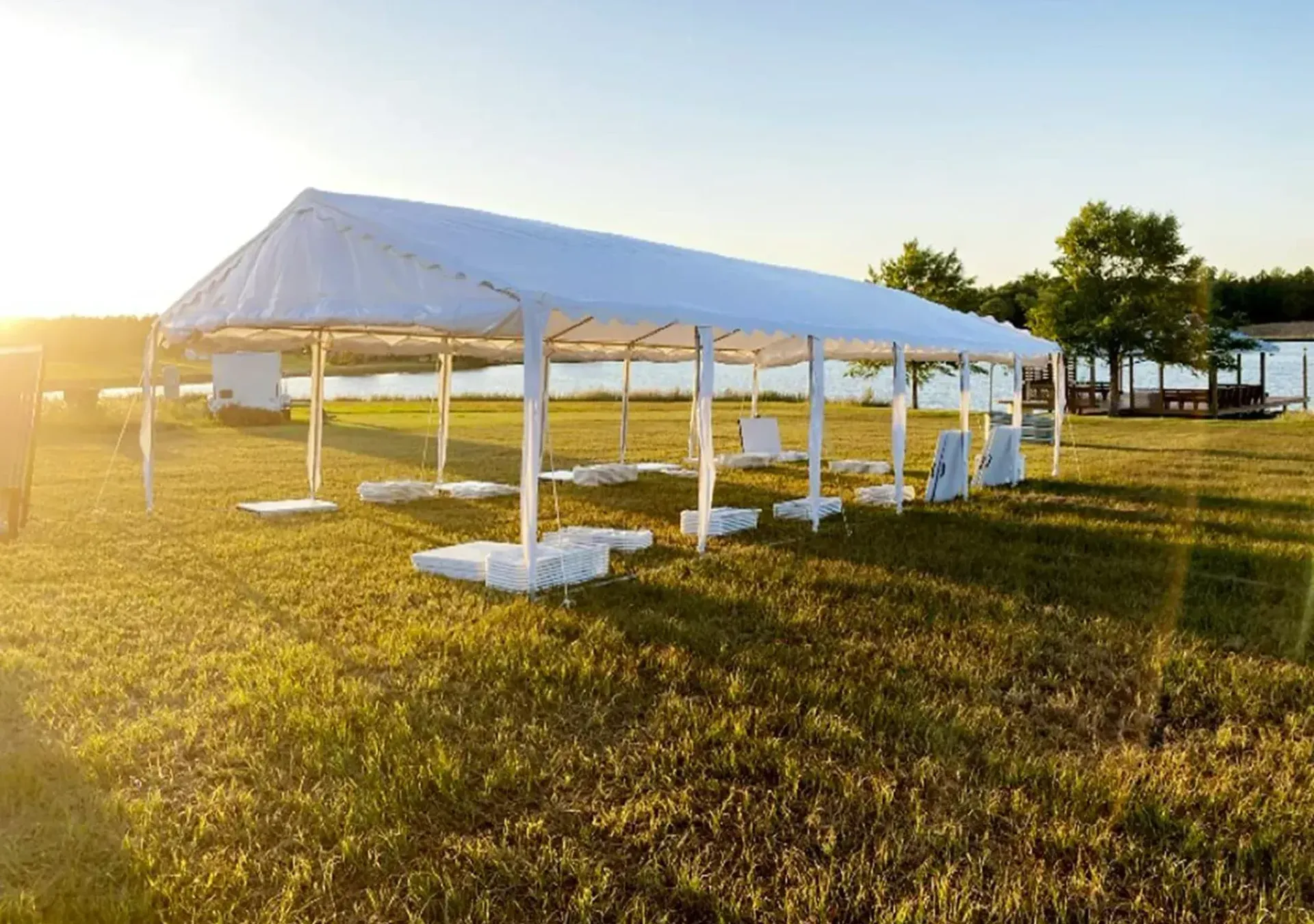 A large white tent is sitting in the middle of a grassy field.