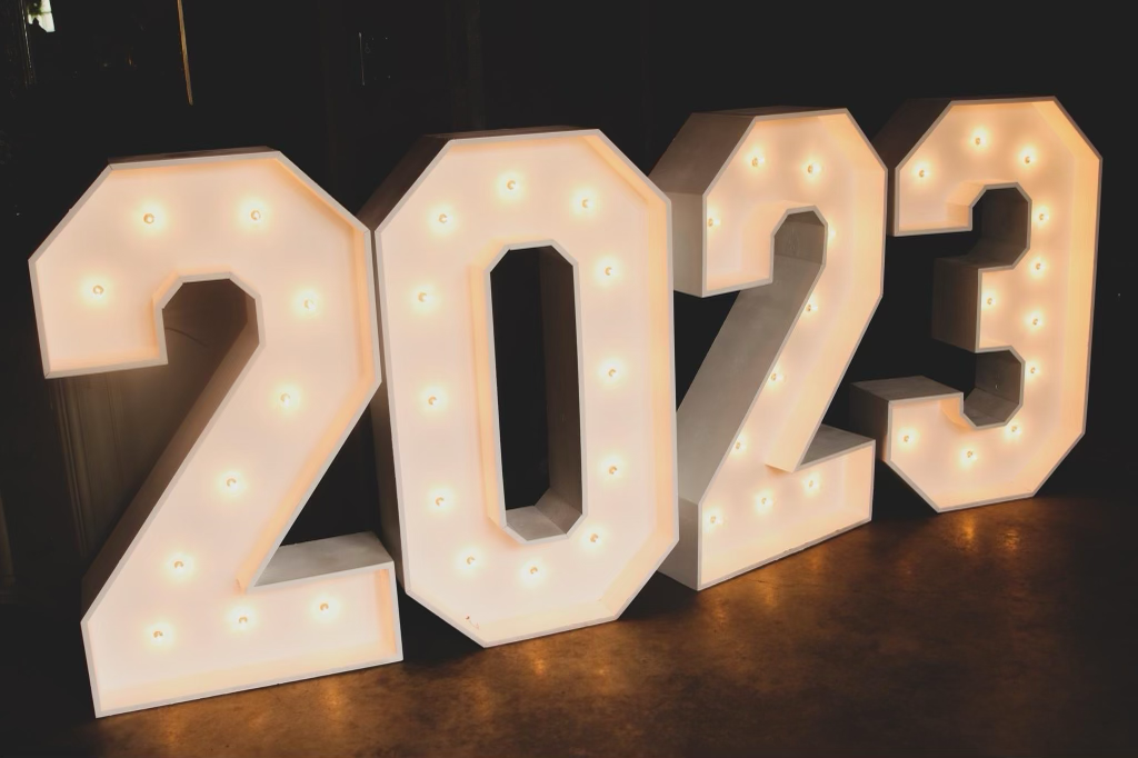 A sign that says 2023 is lit up in the dark
