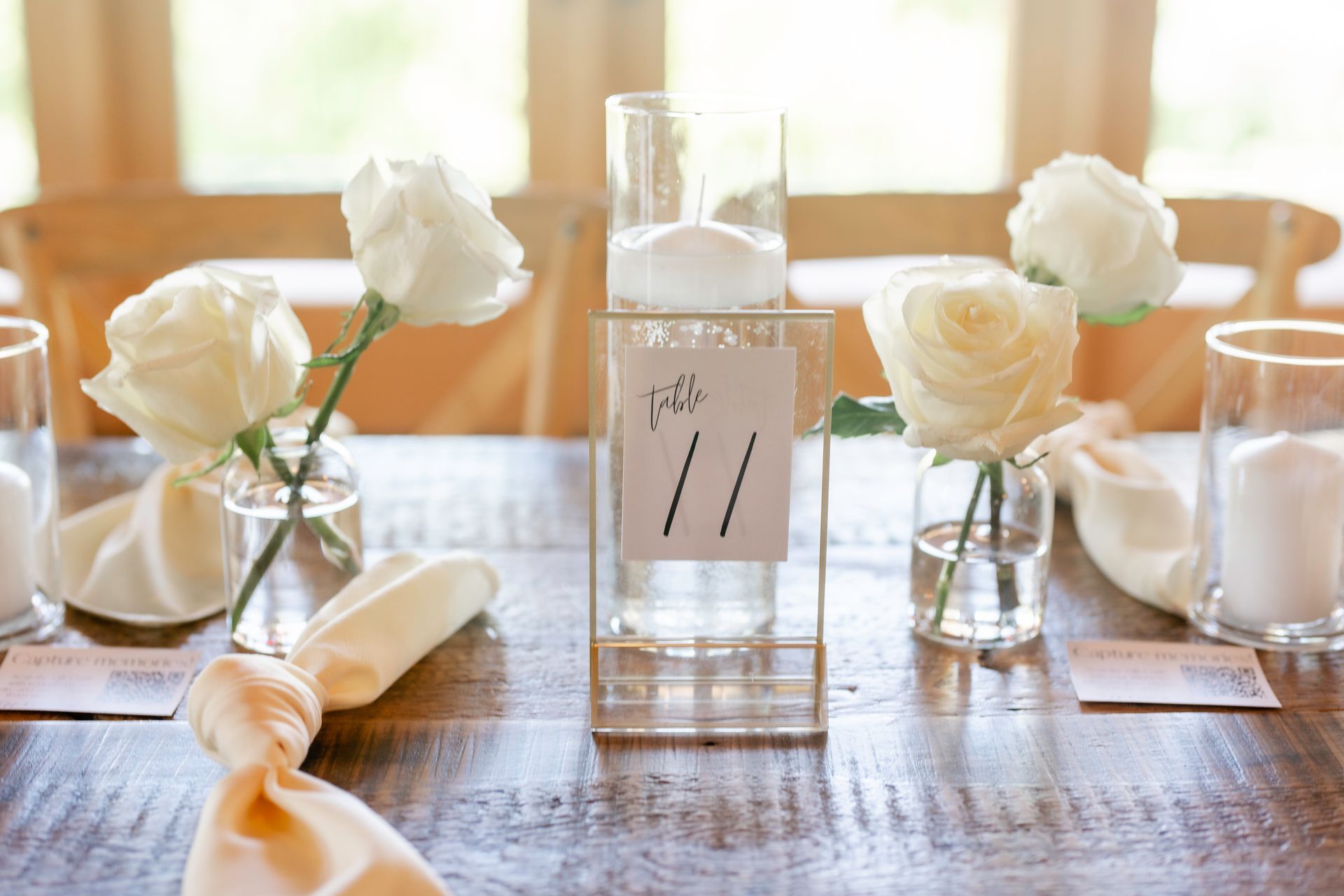 A wooden table with a table number and candles on it.