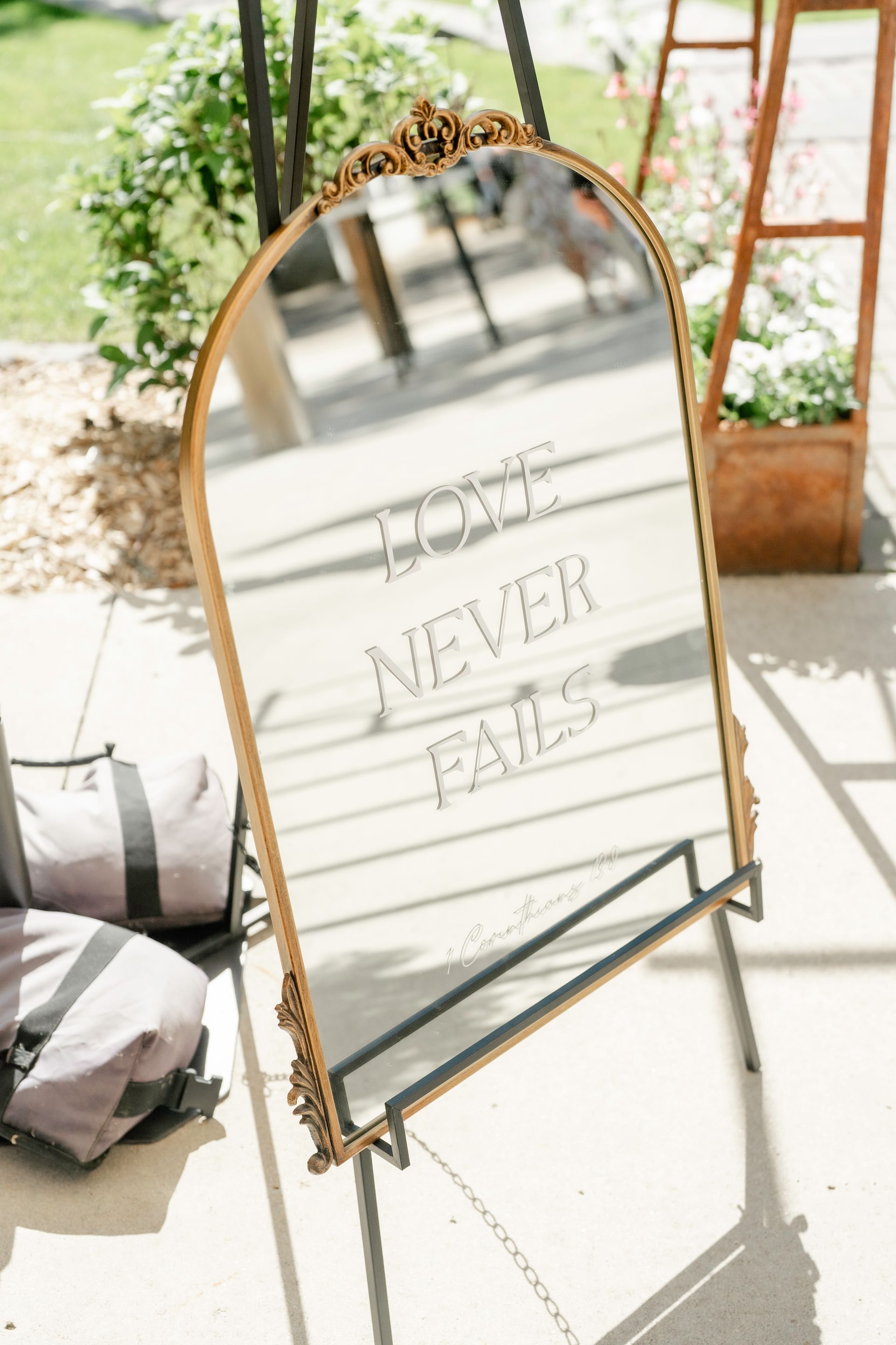 A large mirror on a stand with the words `` never fails '' written on it.