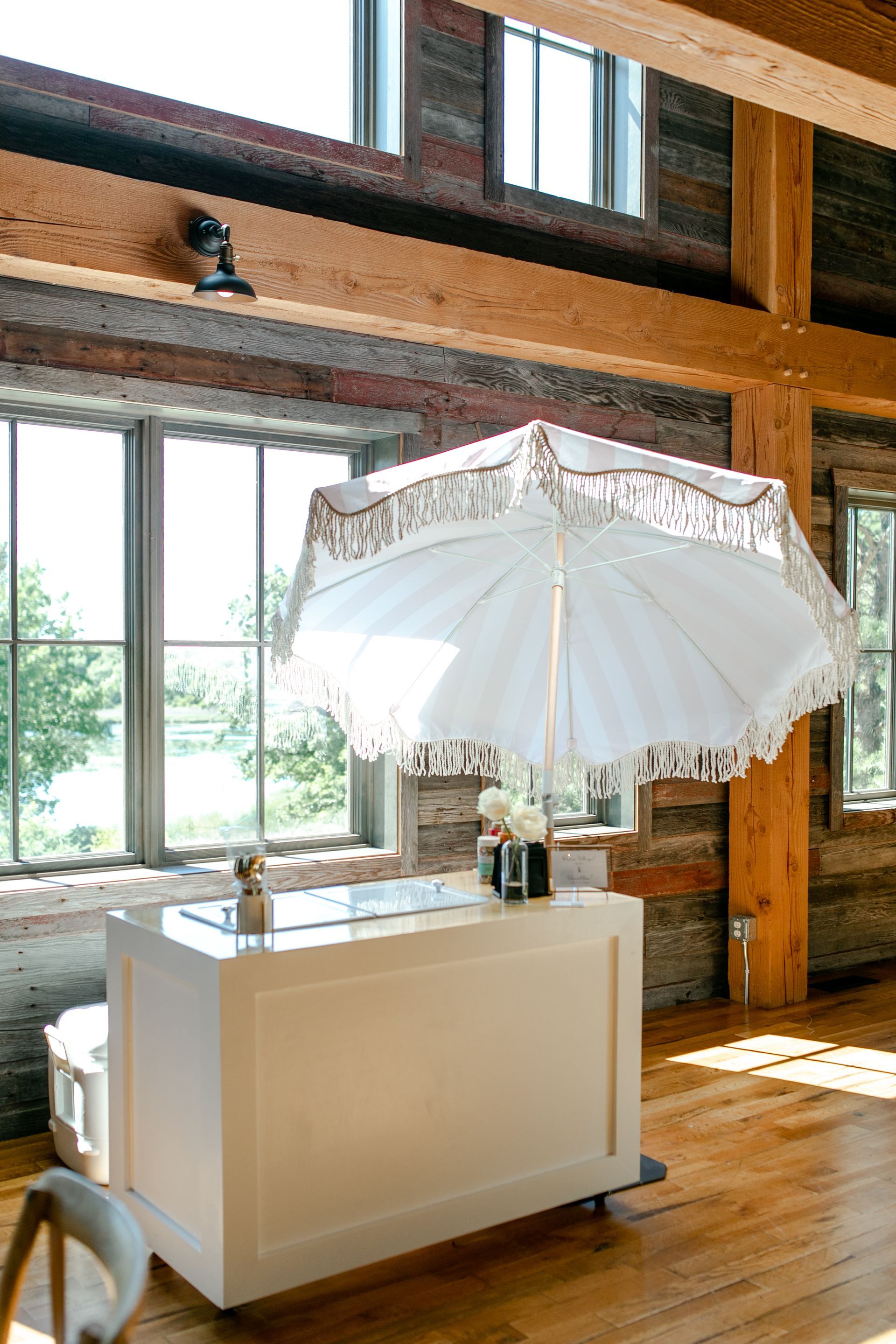 A white umbrella is sitting on top of a white table in a room.