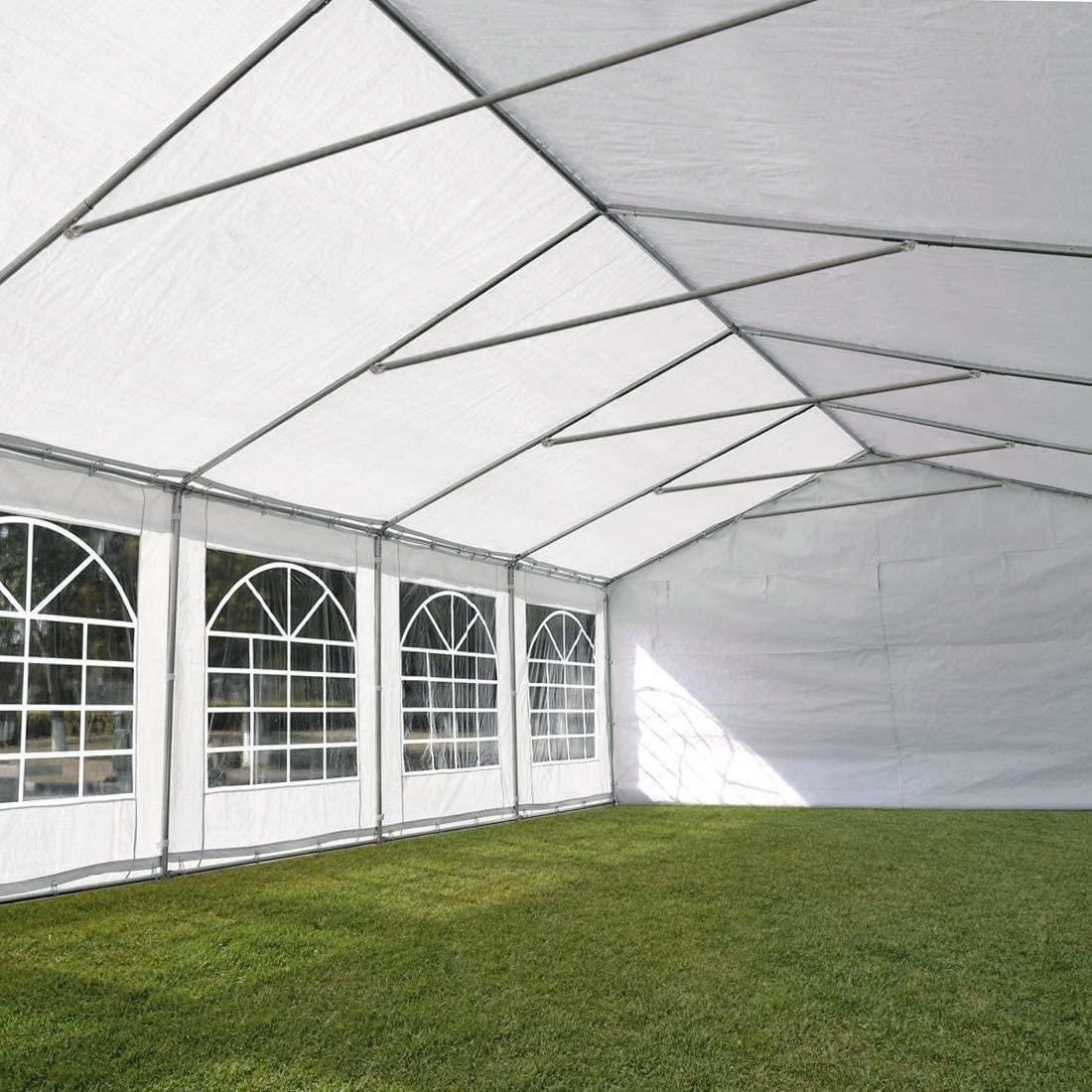 A large white tent is sitting in the middle of a grassy field.