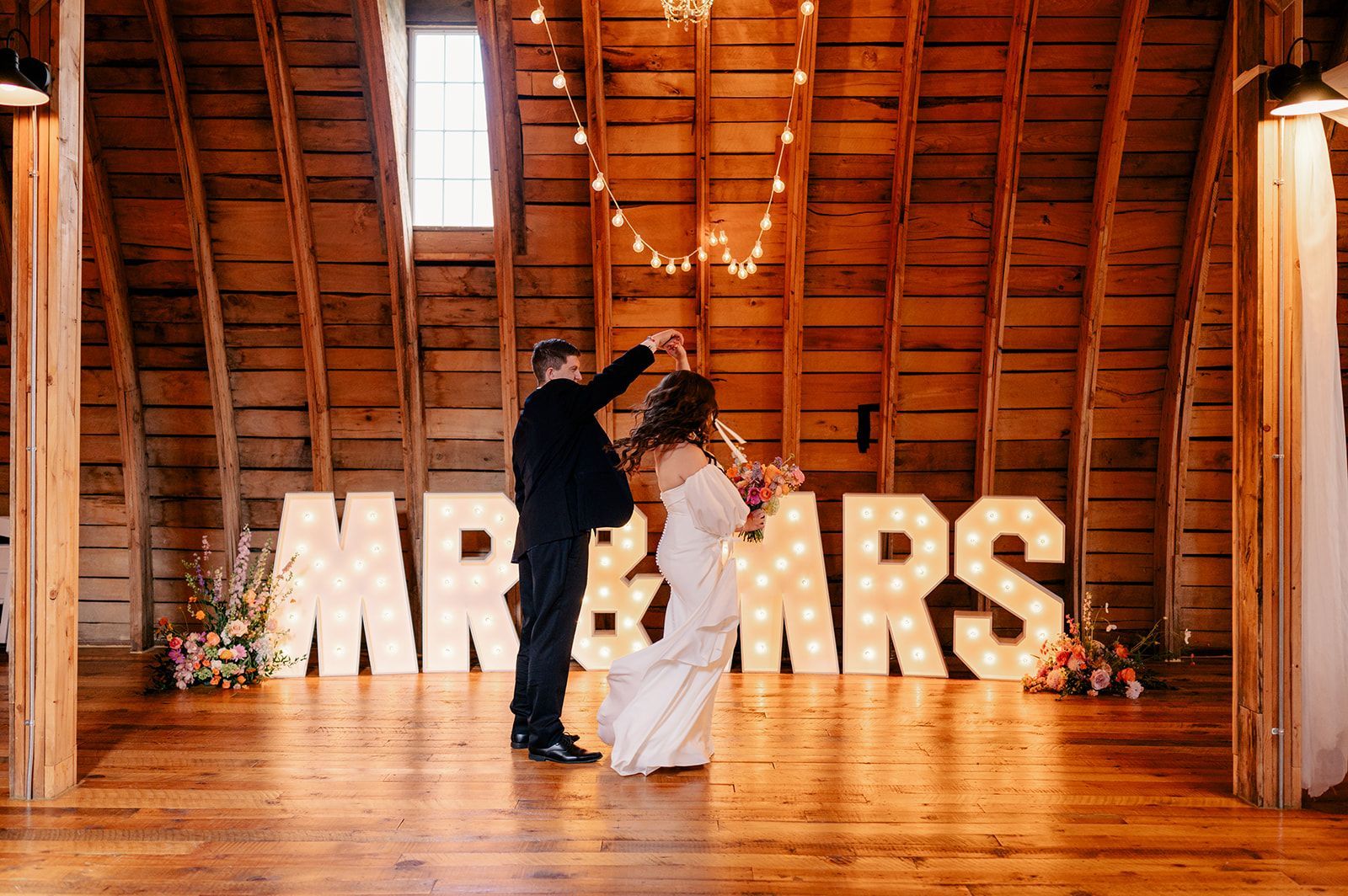 The letters mr and mrs are lit up in a barn.