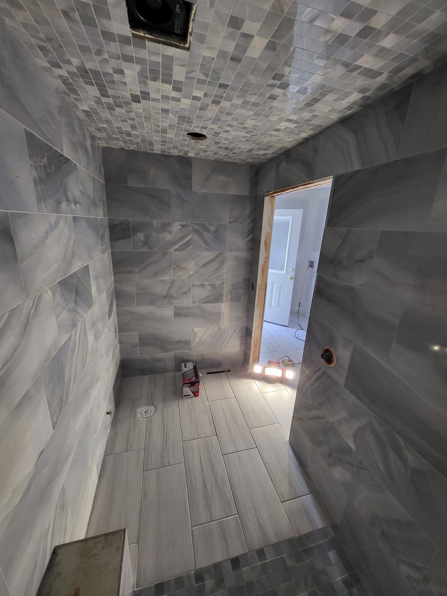 Narrow unfinished stone room with white floorboards and an open doorway letting in bright light
