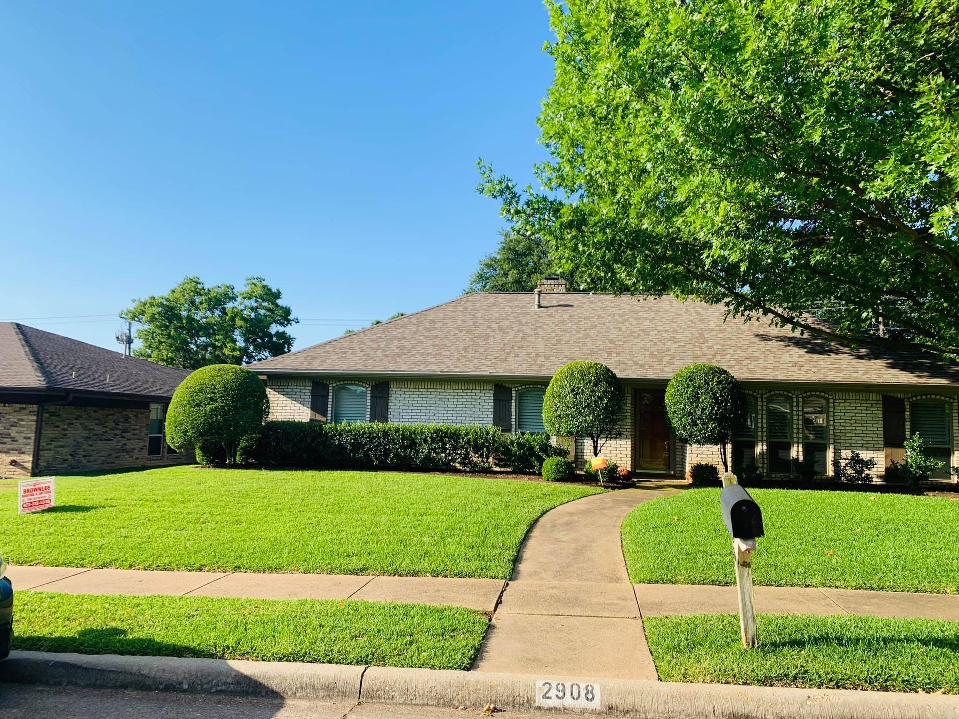 A house with a lush green lawn and a mailbox in front of it