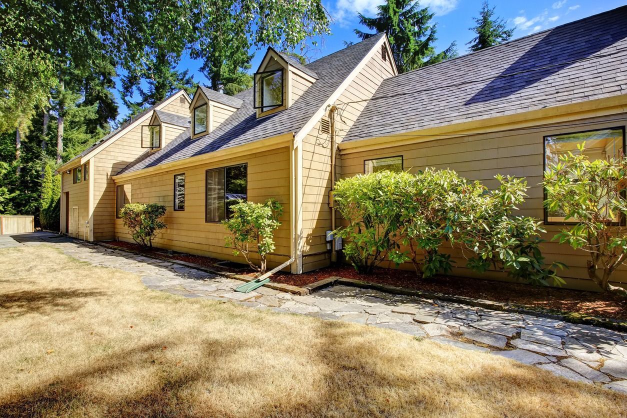 A large house with a lot of windows and a driveway leading to it.