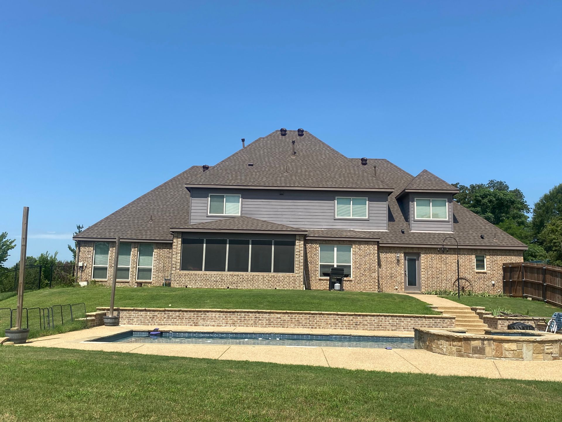 A large brick house with a swimming pool in the backyard