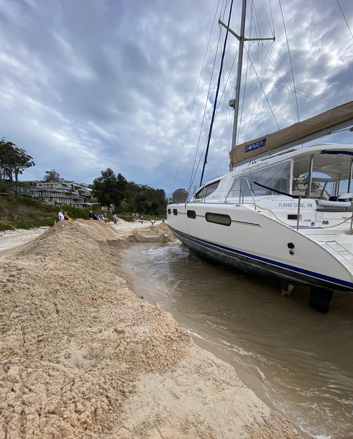 A Sailboat Beached on Sand, Waves Lapping at Its Hull — M&J Marine Services in Medowie, NSW