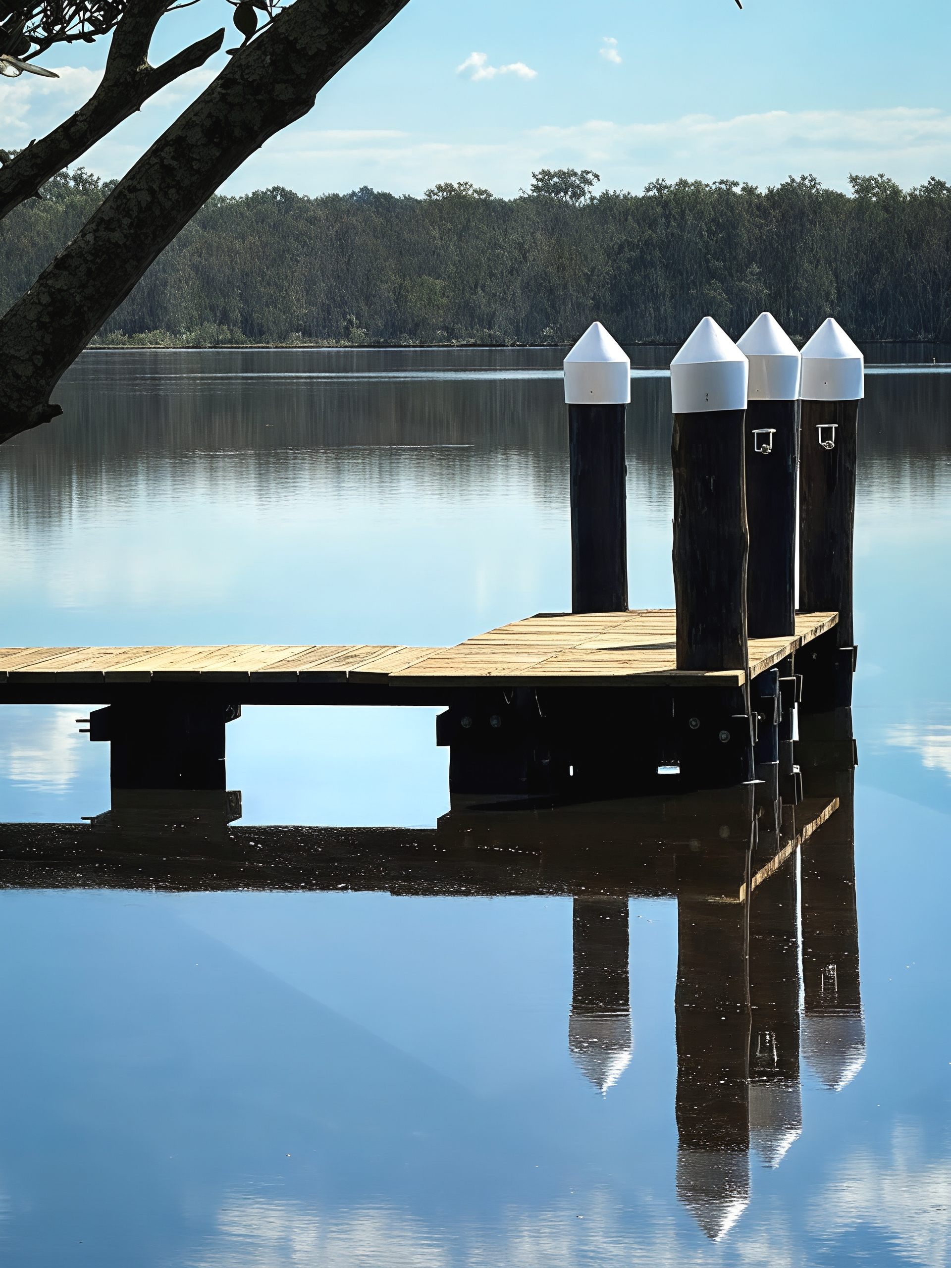 Wooden Dock with White Topped Posts Reflected in Calm Water — M&J Marine Services in Newcastle, NSW