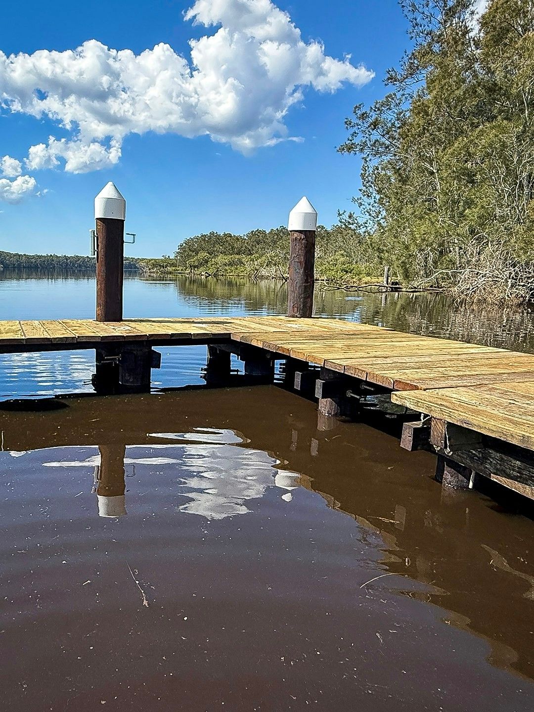 Wooden Dock on Dark Water with White-Topped Posts — M&J Marine Services in Medowie, NSW