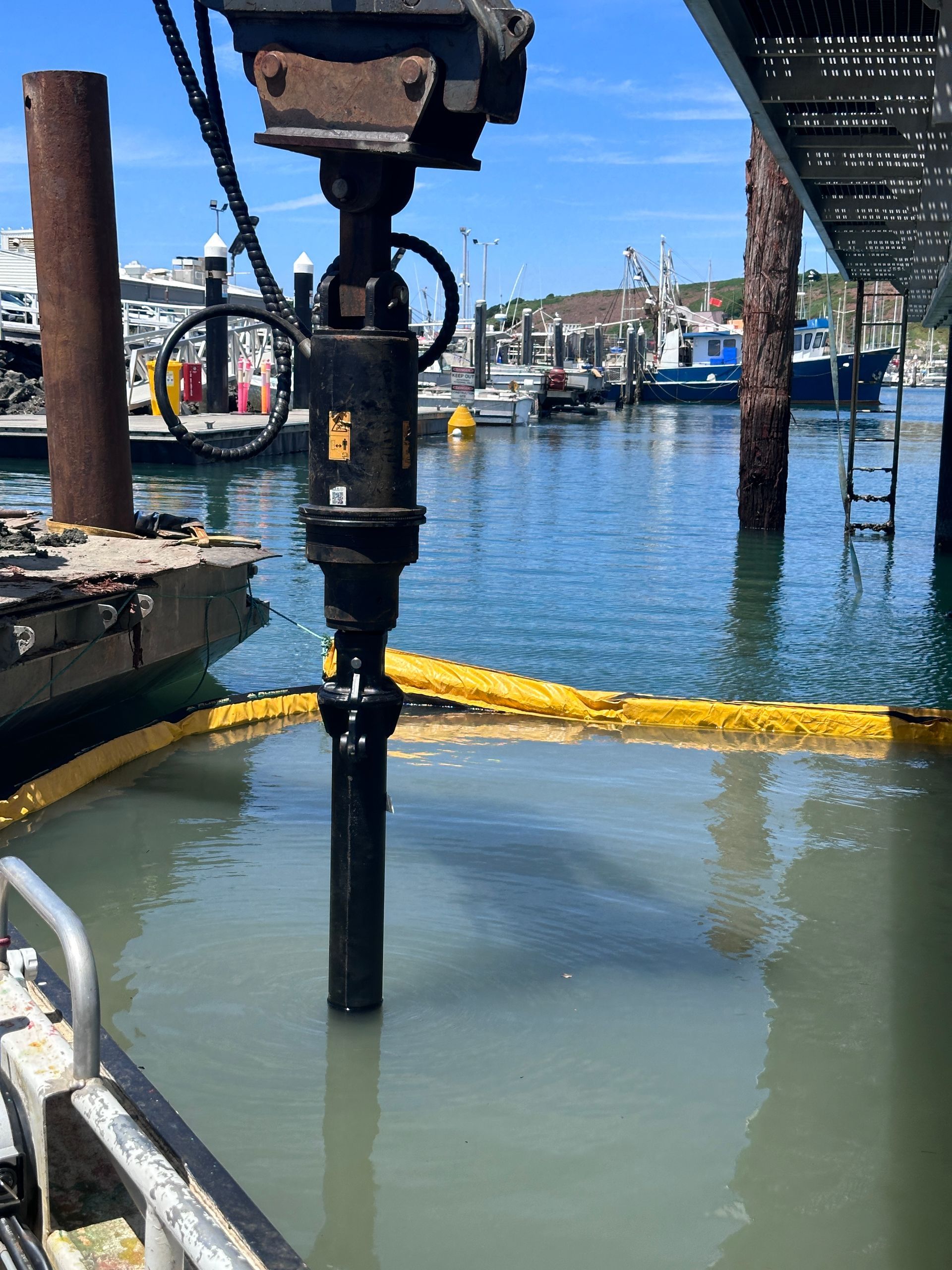 Drill Extending Into Water at A Harbor with Boats in The Background — M&J Marine Services in Newcastle, NSW