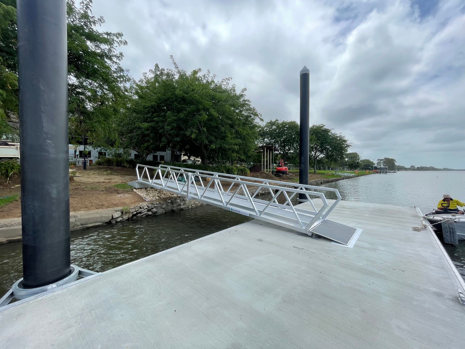 A Metal Gangway Connects a Paved Dock to A Grassy Shoreline — M&J Marine Services in Lake Macquarie, NSW