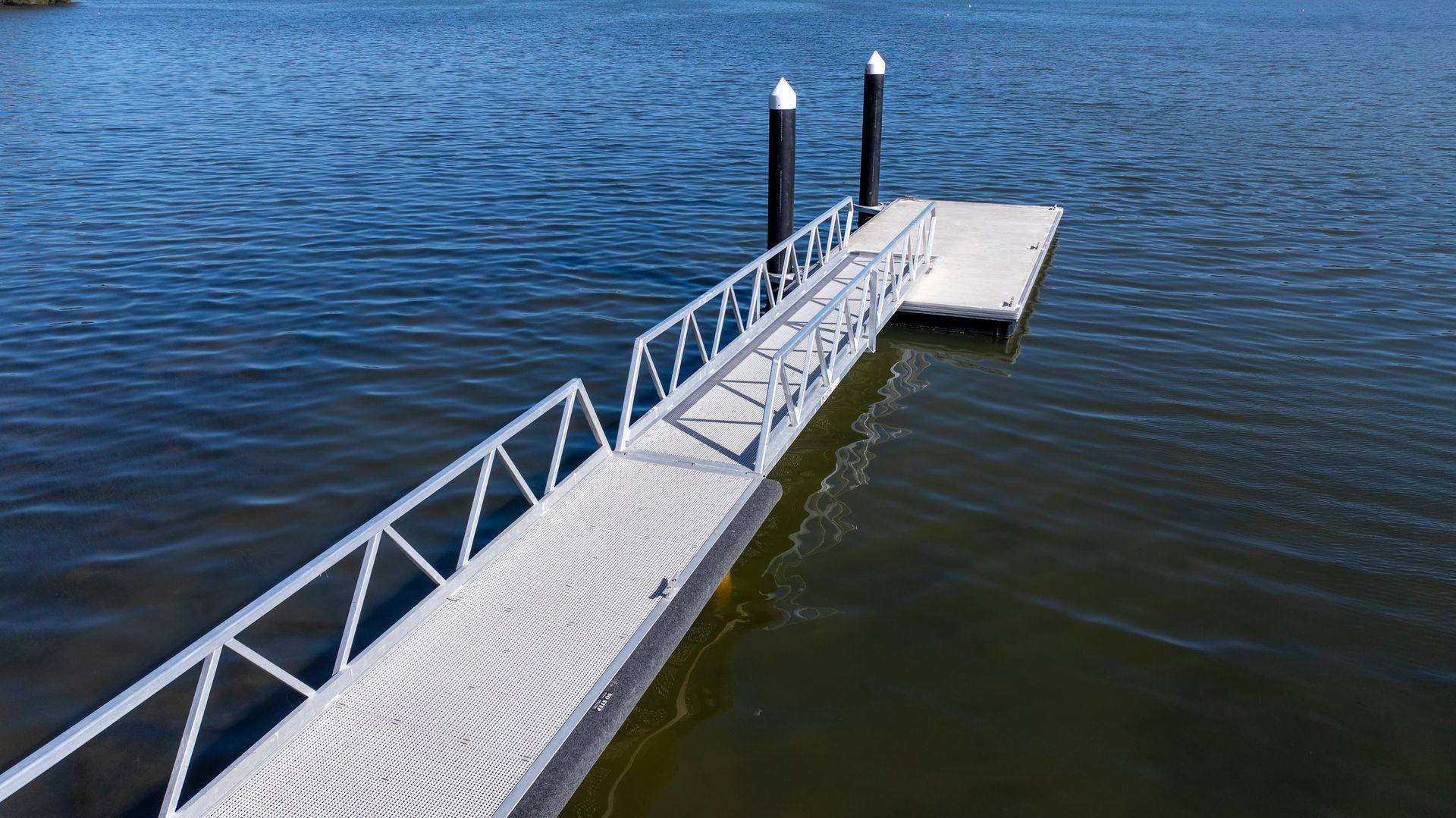 A Metal Pier with A Railed Walkway Extending from The Shore — M&J Marine Services in Medowie, NSW
