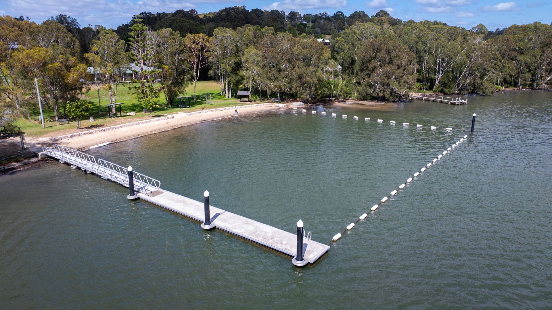 An Aerial View of A Wooden L Shaped Jetty Extending Into a Calm Bay — M&J Marine Services in Forster, NSW
