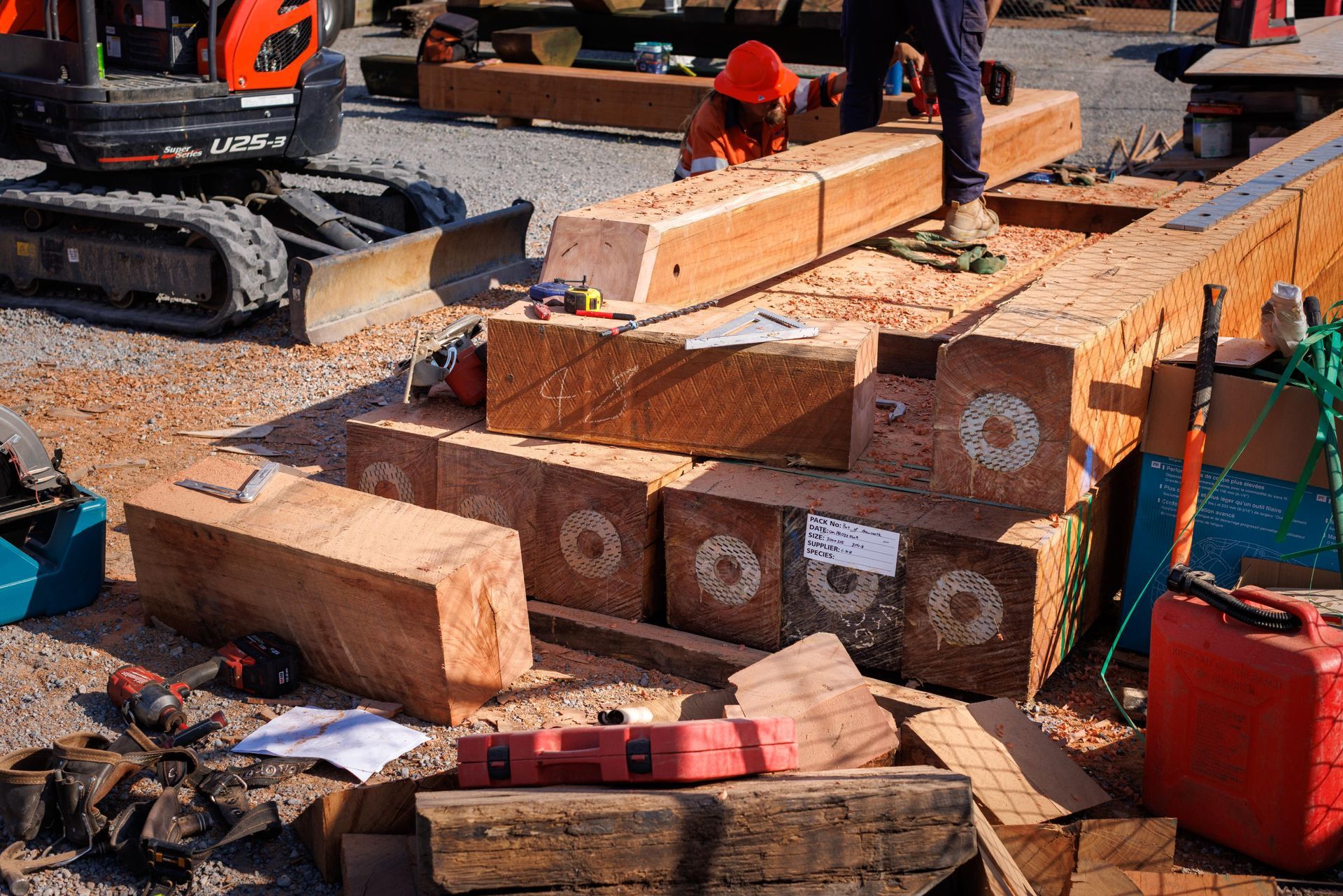 Stacked Timber Beams at An Outdoor Construction Site — M&J Marine Services in Medowie, NSW