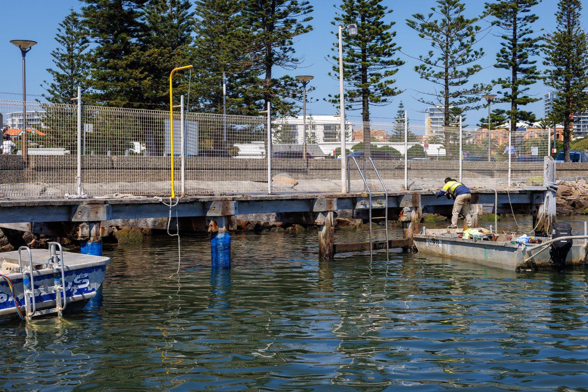 A Person on A Metal Pier Structure Over Water Next to A Boat — M&J Marine Services in Lake Macquarie, NSW