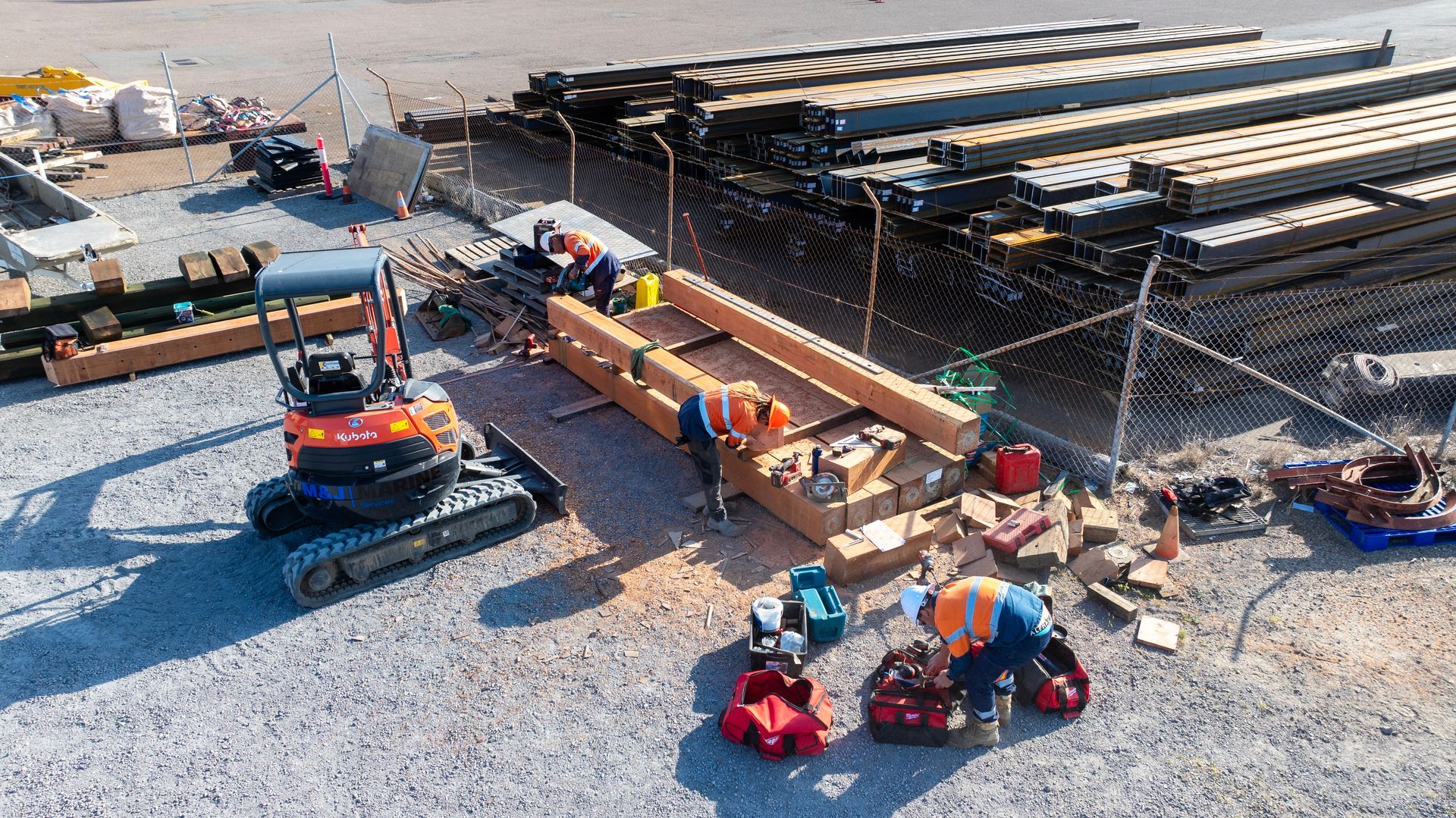 Three Workers in High-Visibility Vests Work on Large Wooden Beams — M&J Marine Services in Newcastle, NSW
