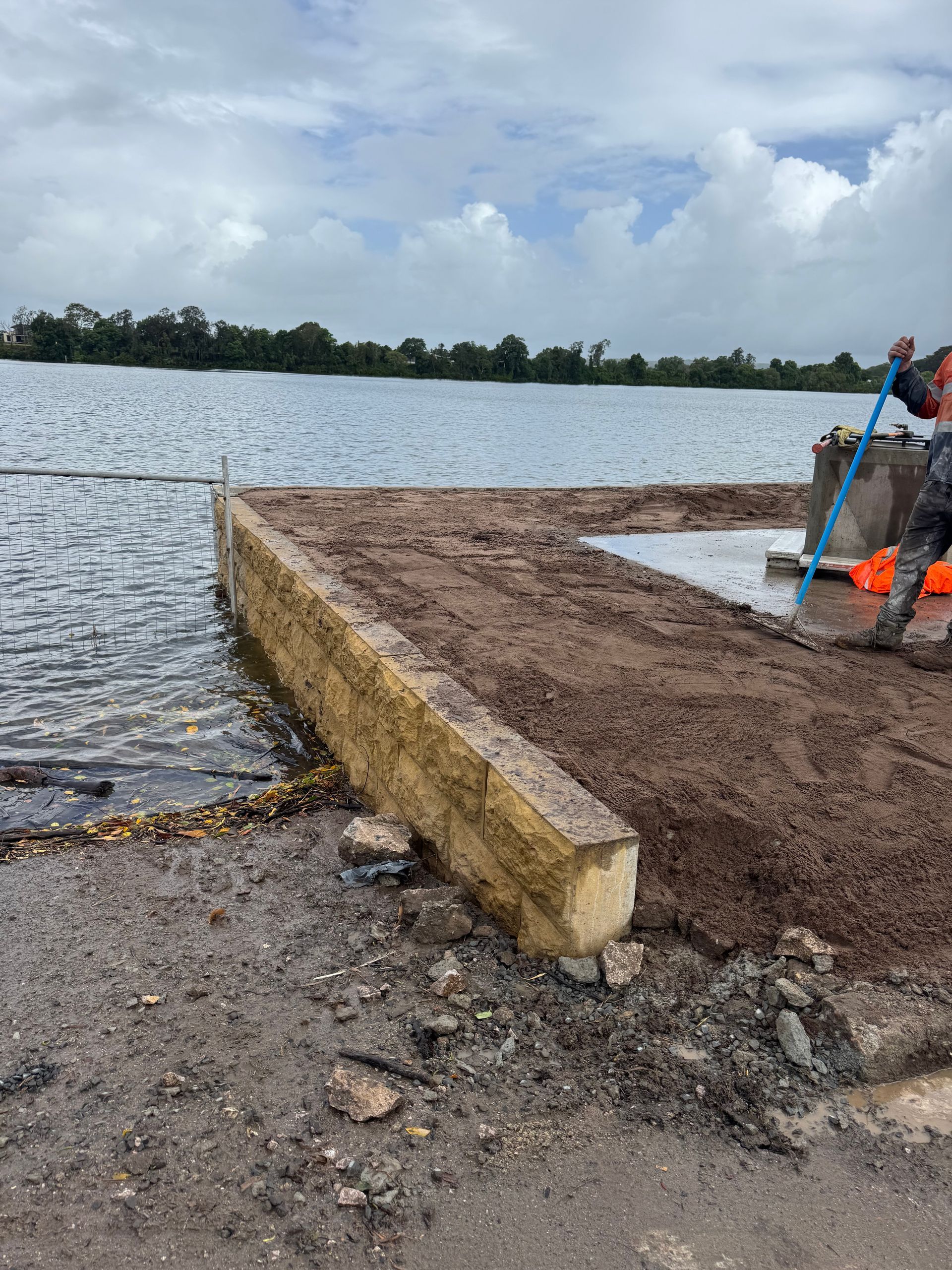 A Tan Stone Retaining Wall Borders a Construction Site Beside a Lake — M&J Marine Services in Forster, NSW