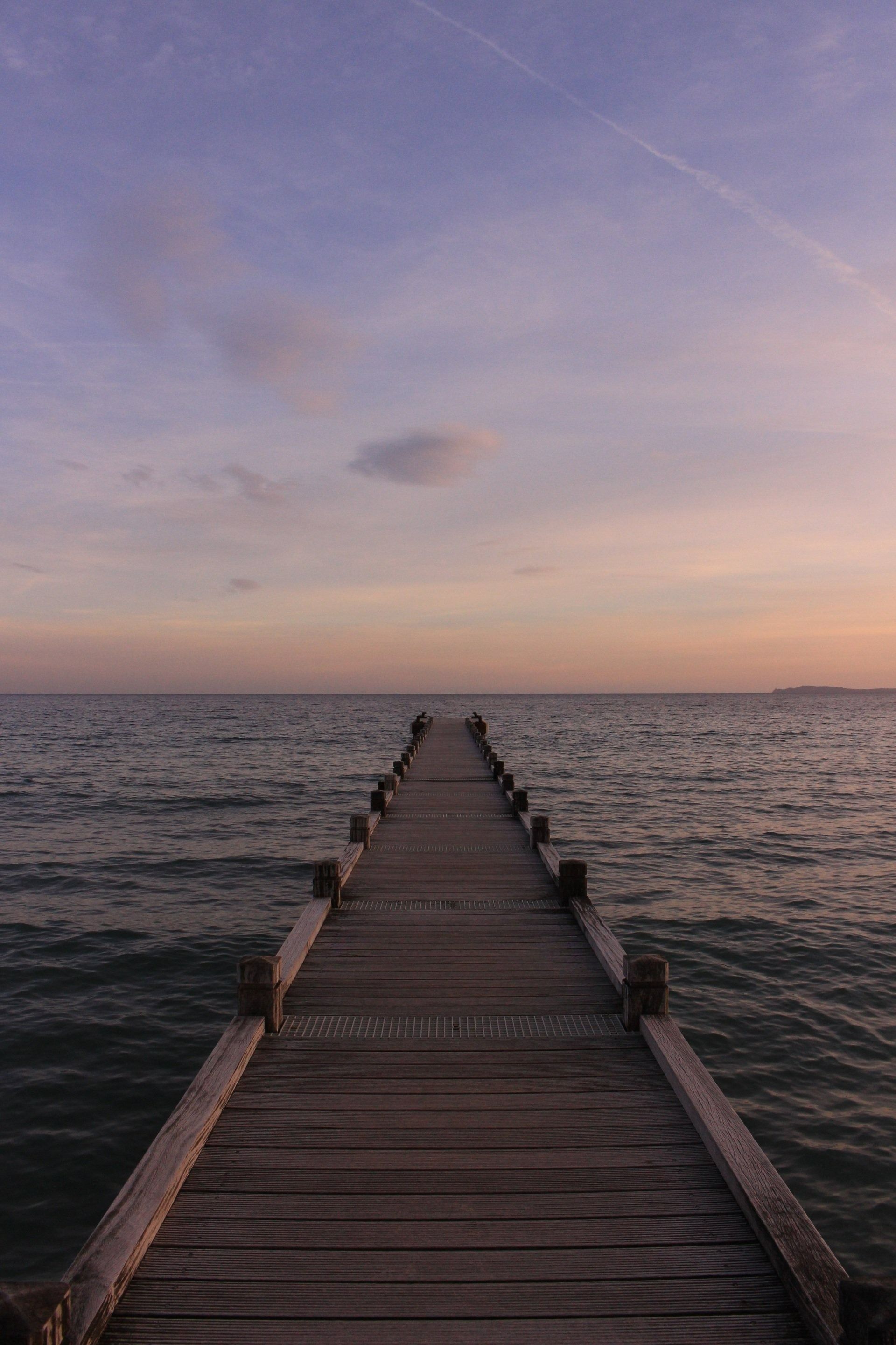 Wooden Pier Extends Towards the Horizon, Over a Calm Sea at Sunset — M&J Marine Services in Coffs Harbour, NSW