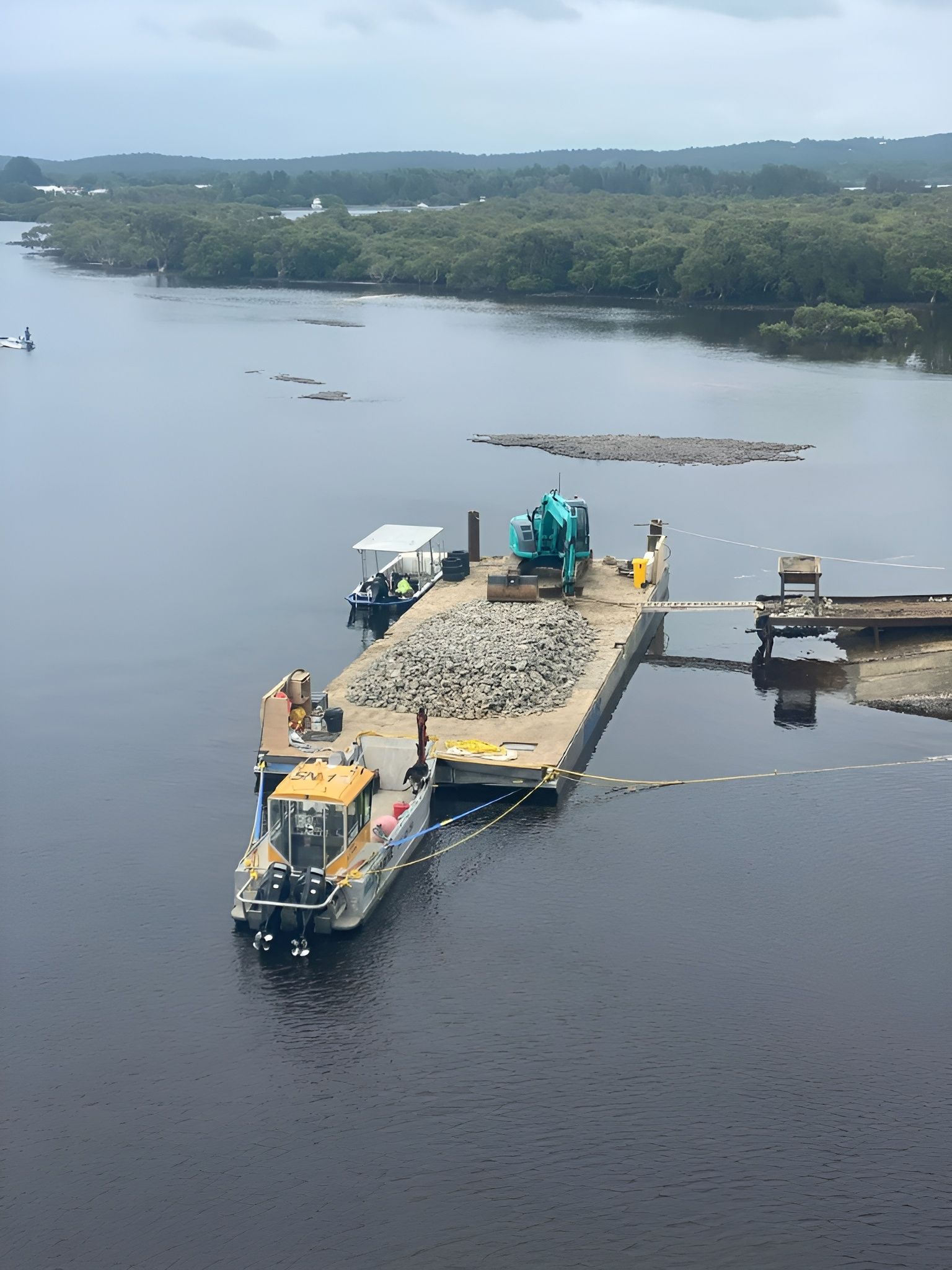 Barge on River with Excavator, Backhoe, and Pile of Rocks — M&J Marine Services in Medowie, NSW