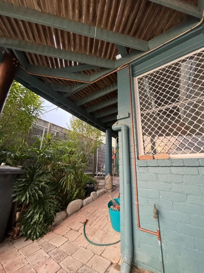 A Hose Is Hanging From The Side Of A Building — Oceanforce Plumbing In Blacksmiths, NSW