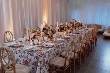 A long table with plates , candles , and flowers on it.