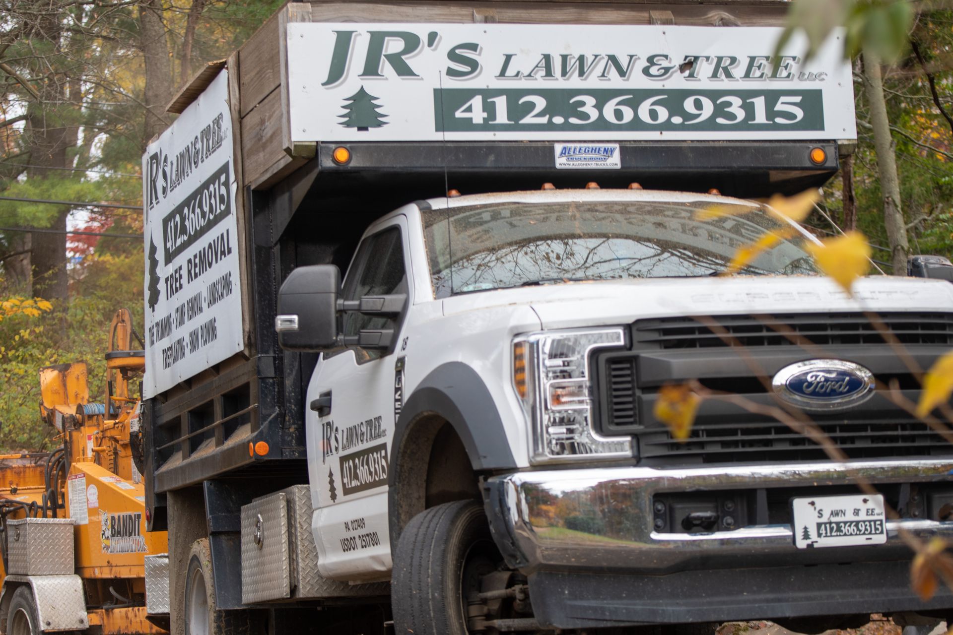 a jr 's lawn and tree truck is parked on the side of the road .