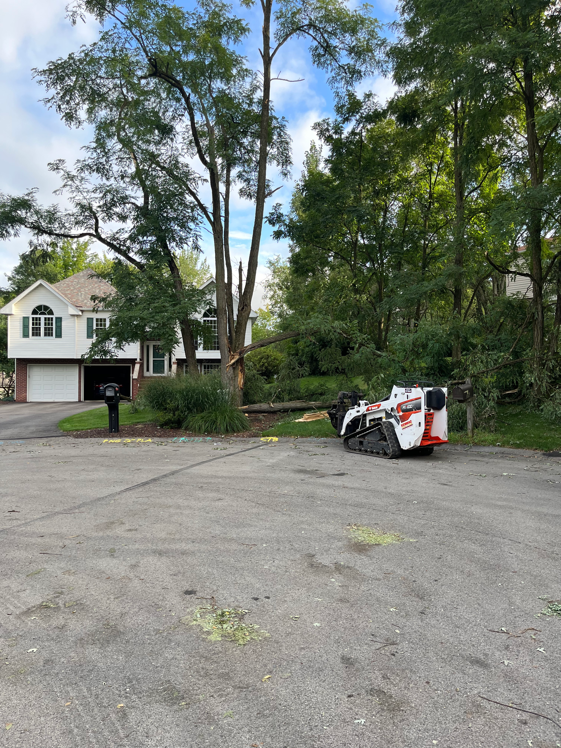 a bobcat is parked in a parking lot in front of a house .