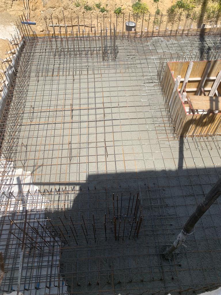 Cantiere edile con griglia di armatura e casseforme per solette in cemento in fase di realizzazione