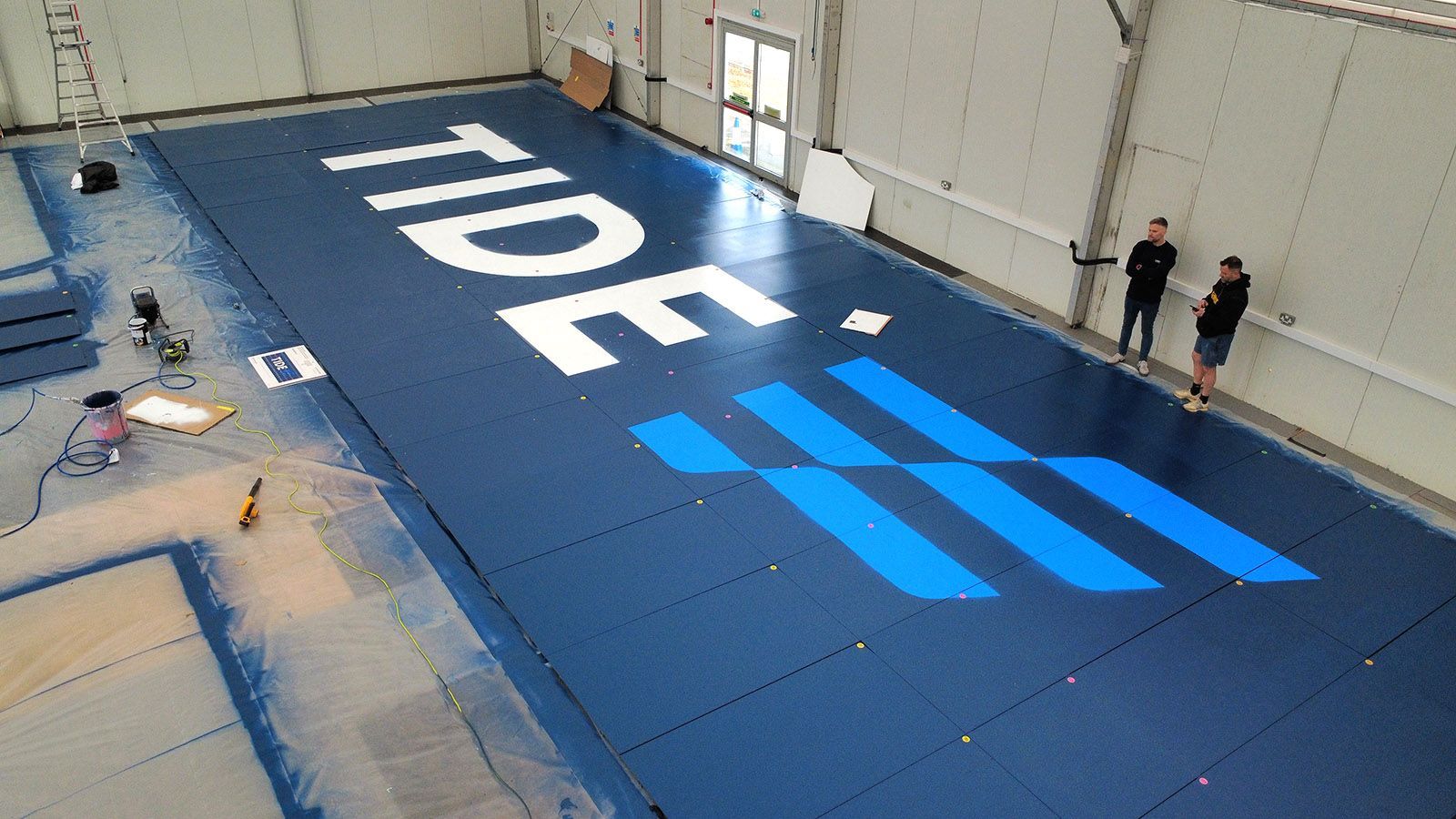 Tide logo large format cladding being painted