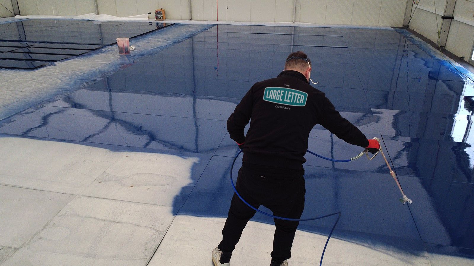 Tide logo large format cladding being sprayed