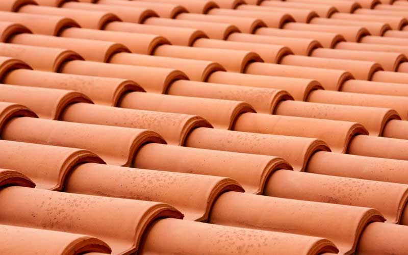 Tuiles de toit en terre cuite rouge à motif répétitif.