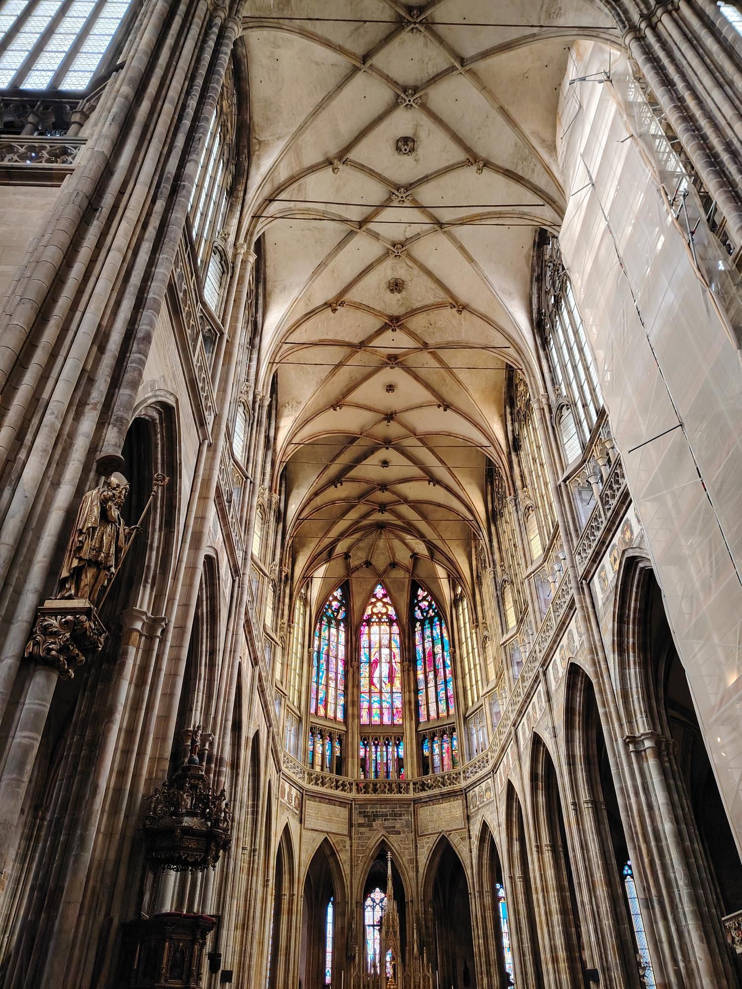 Gothic cathedral interior with soaring vaulted ceiling and stained-glass windows
