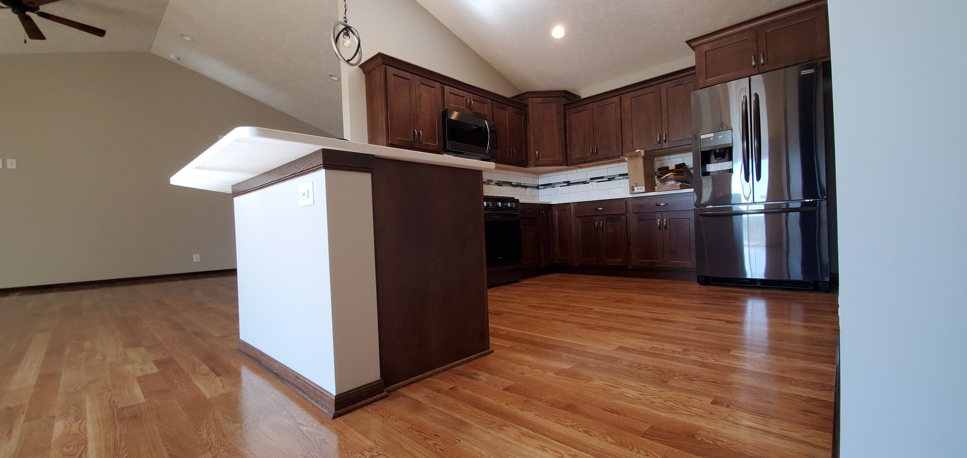 Natural hardwood flooring connecting a kitchen and living room