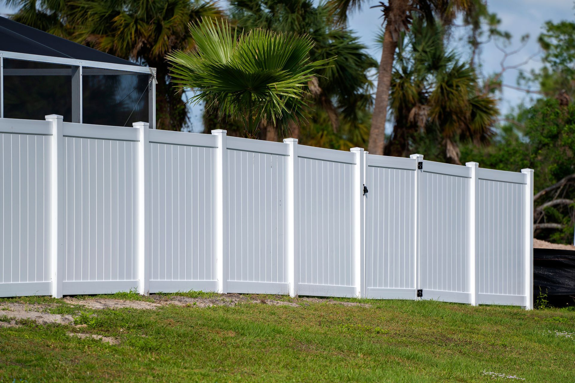 A white fence with a blue sky in the background