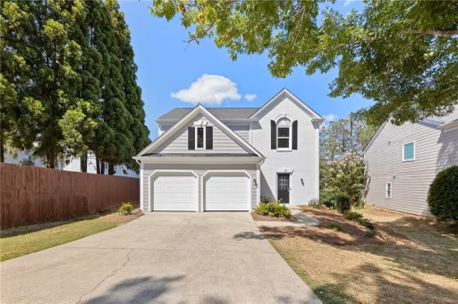 A large white house with two garages and a driveway