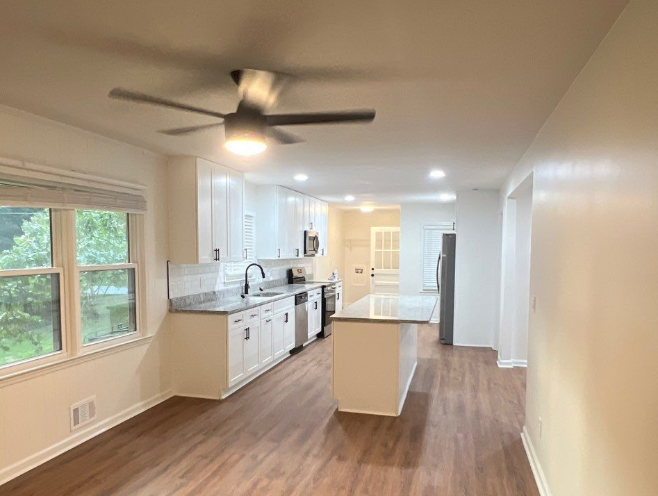 A kitchen with a stove and pots and pans hanging on the wall